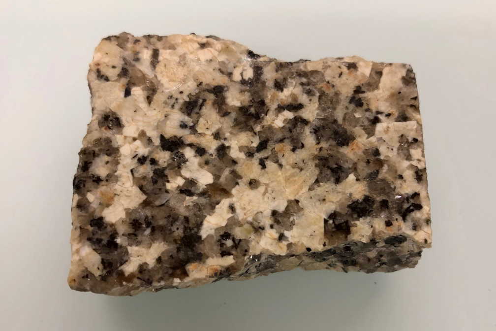 Das Gestein Granit besteht aus den drei Mineralien bzw. Reinstoffen Quarz (grau), Feldspat (gelbweiss) und Glimmer (schwarz)
